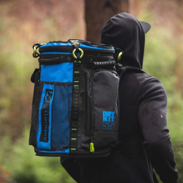 Arbortec Blue Gear Bag  feature- 55 Litre - an arborist with the backpack in a green background